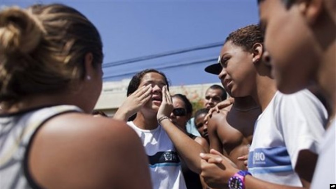 A student tells her schoolmates that she saw dead bodies inside their school after a shooting in Rio de Janeiro, Brazil, April 7, 2011