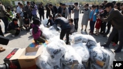 North Korean defectors carry plastic bags of leaflets condemning Pyongyang’s government policies. Leaflets attached to balloons get sent from the border town of Paju, South Korea, on Oct. 10, 2014.