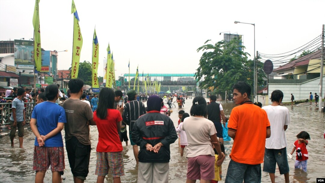 Residents of Kampung Melayu look at the flood waters on a bridge, South Jakarta, Indonesia, January 17, 2013. (K. Lamb/VOA)