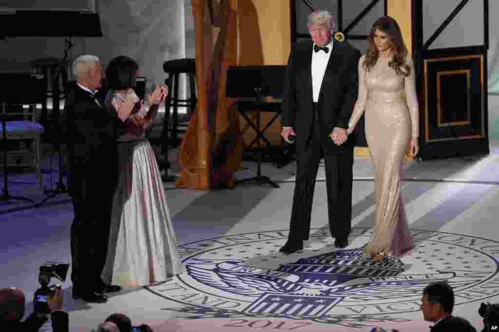 Le vice-président élu, à gauche, avec sa femme Karen, deuxième à droite, applaudissent le président élu Donald Trump et sa femme Melania à leur entrée au dîner avec des donateurs, 19 décembre 2017.