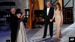 Le vice-président élu, à gauche, avec sa femme Karen, deuxième à droite, applaudissent le président élu Donald Trump et sa femme Melania à leur entrée au dîner avec des donateurs, 19 décembre 2017.