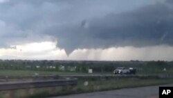 In this frame from video, a tornado moves through Longmont, Colo., Thursday, June 4, 2015.