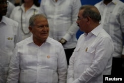 Dominican Republic President Danilo Medina, right, speaks to Salvadorian President Salvador Sanchez Ceren before posing for an official photograph during the Community of Latin American and Caribbean States summit, Jan. 25, 2017.
