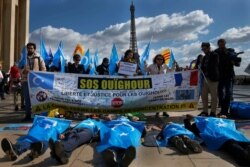 Aksi unjuk rasa Komunitas Uyghur Prancis menyuarakan catatan hak asasi manusia China di dekat Menara Eiffel, Prancis, 25 Maret 2019. (AFP)