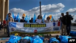 (FILES) Foto bertanggal 25 Maret 2019 ini menunjukkan para demonstran Komunitas Uighur Prancis membawa bendera Turkestan Timur (Uighur) dalam protes terkait rekor HAM China di dekat Menara Eiffel. (Foto: AFP)