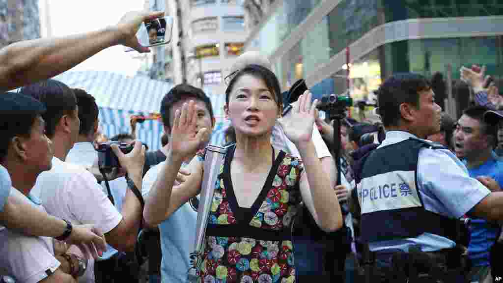 Main levée, une manifestante pro-démocratie consent de quitter le lieu de la manifestation quand des policiers interviennent pour empêcher des affrontements avec des résidents et partisans pro-Pékin à Kowloon, un quartier bondé du district Mong Kok à Hong Kong, &nbsp;3 octobre 2014. 