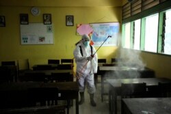 Petugas menyemprotkan disinfektan di ruang kelas sebuah sekolah di tengah pandemi Covid-19 di Jakarta.