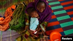 Bonko Diawara holds her 17-month-old daughter, Diarra Yattibere, as she recovers from malnutrition, at a nutrition center at Selibaby's hospital, in the Guidimakha region, Mauritania, June 2012.