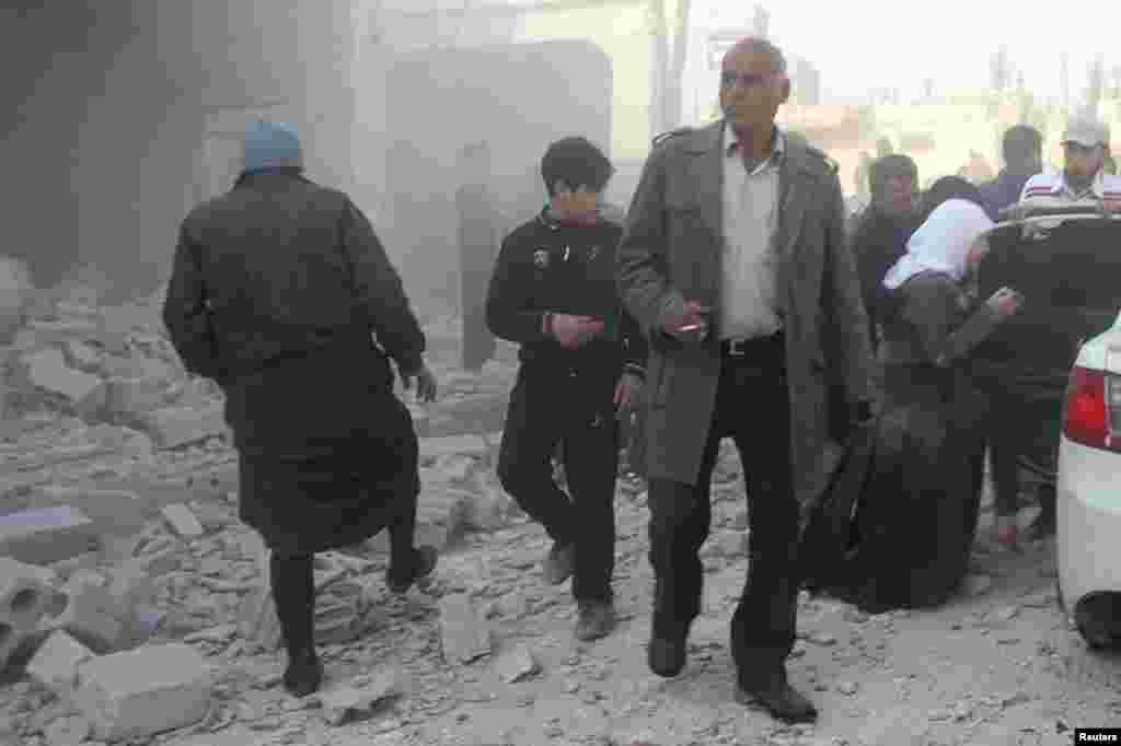 Residents inspect damage after what activists said was shelling from forces loyal to President Bashar al-Assad in Al-Atareb, Aleppo countryside, Syria, Feb. 16, 2014. 