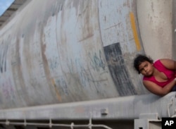 FILE - A young migrant girl waits for a freight train to depart on her way to the U.S. border, in Ixtepec, Mexico, July 12, 2014.