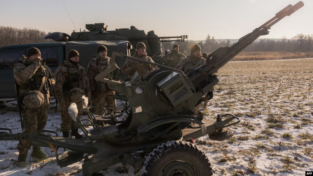 Prajurit Ukraina dari tim pemburu drone berdiri di samping autocannon anti-pesawat laras ganda yang mereka gunakan untuk menargetkan drone yang diluncurkan Rusia, di pinggiran Kyiv, pada 30 November 2023, di tengah invasi Rusia ke Ukraina.