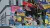 Un niño toma una fotografía de un monumento improvisado para los soldados ucranianos caídos en la Plaza de la Independencia en Kiev, el 26 de julio de 2024, en medio de la invasión rusa en Ucrania. [Foto de Sergei SUPINSKY / AFP]