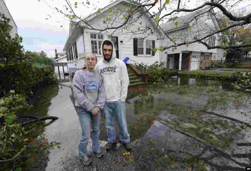 Kathy and Jeffrey Frey pose for a photograph outside their home on 7th Street which is flooded from the effects of Hurricane Sandy on Oct., 30, 2012, in Bayville, N.Y.