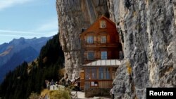 Para penggemar hiking berdiri di depan hotel Berggasthaus Aescher-Wildkirchli di wilayah pegunungan Alpstein dekat Weissbad, Swiss, 28 Oktober 2016.