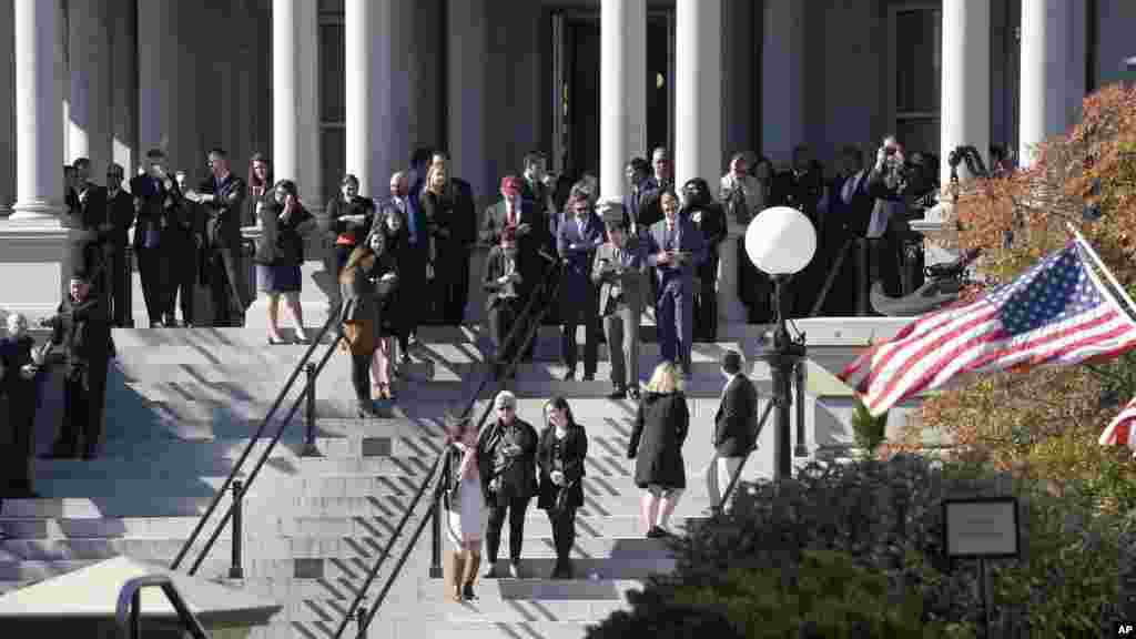 Quelques personnes attendent devant l'immeuble de Eisenhower, à côté de la Maison Blanche, espérant voir Donald Trump au terme de sa rencontre avec Barack Obama à Washington, le 10 novembre 2016.