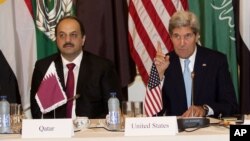 Qatari Foreign Minister Khaled Al Attiyeh, left, and U.S. Secretary of State John Kerry, right, sit alongside each other prior to a meeting with the Arab League in Paris, Monday Oct. 21, 2013. Kerry is in Paris for diplomatic talks about a peace process for Israel and Palestinian authorities. (AP Photo/Michel Euler)