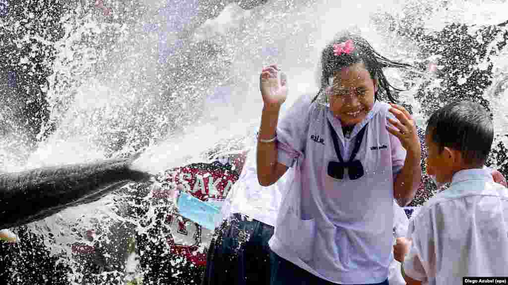 Une écolière dans le festival de l'eau dans la ville antique de Ayutthaya, Thaïlande, le 11 avril 2016.