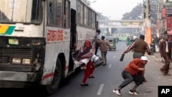 Para penumpang melompat keluar dari bus setelah diancam oleh para aktivis karena tidak mengikuti ajakan aksi mogok memprotes kenaikan harga BBM di Dhaka, Bangladesh (16/2). Seorang penumpang dilaporkan tewas, setelah sebuah kendaraan terbalik akibat sopir kehilangan kendali saat dikejar oleh para aktivis tersebut.