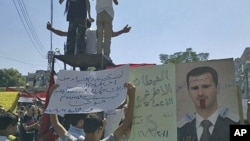 The banners read "The deaf and the blind devil" (L) and "Step down devil" (C), as people protest against Syrian President Bashar al-Assad after Friday prayers in the city of Homs, September 16, 2011.