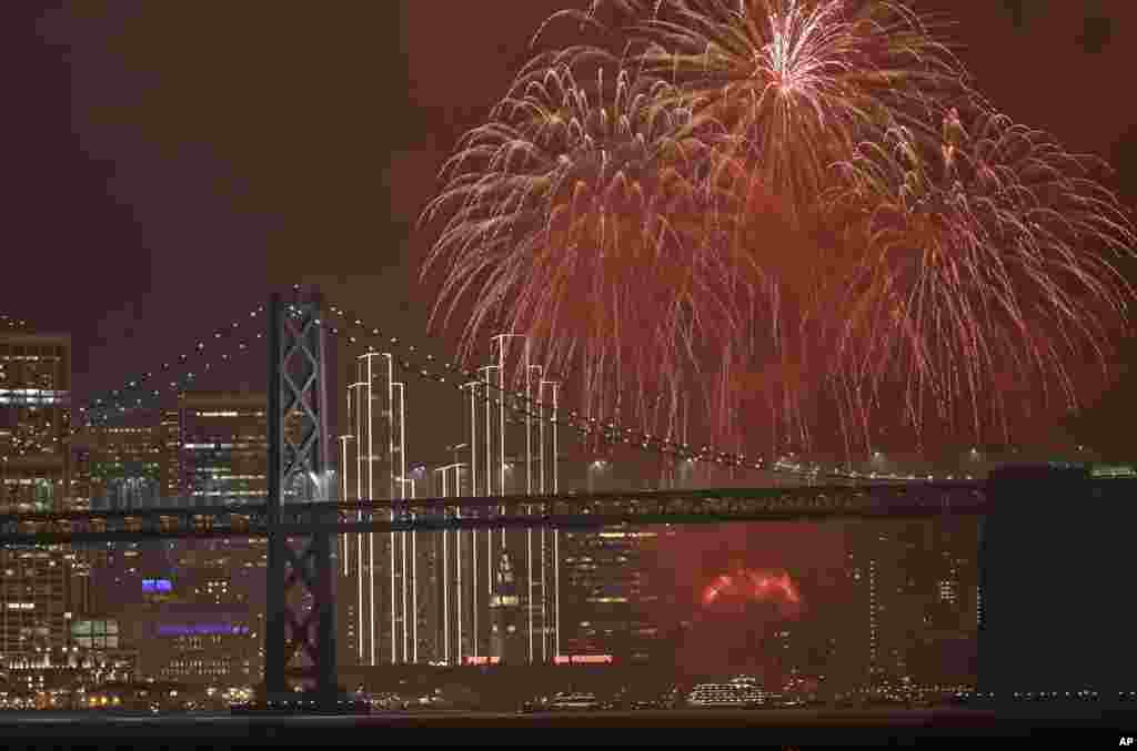 Pertunjukan kembang api di atas Jembatan San Francisco Oakland Bay menyambut datangnya tahun baru 2017 (1/1) di San Francisco. (AP/Marcio Jose Sanchez)