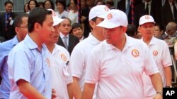 Cambodian Prime Minister Hun Sen's son, Hun Many, second right, walks on the red carpet during a celebration marking the anniversary of the 1979 downfall of the Khmer Rouge regime at Hun Sen's ruling Cambodian People's Party, in Phnom Penh, file photo. 