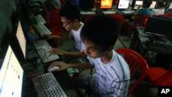 FILE - two Vietnamese students use Facebook at an internet cafe near their dormitory while they could not log in Facebook from their mobile phones because of firewall in Hanoi, Vietnam.
