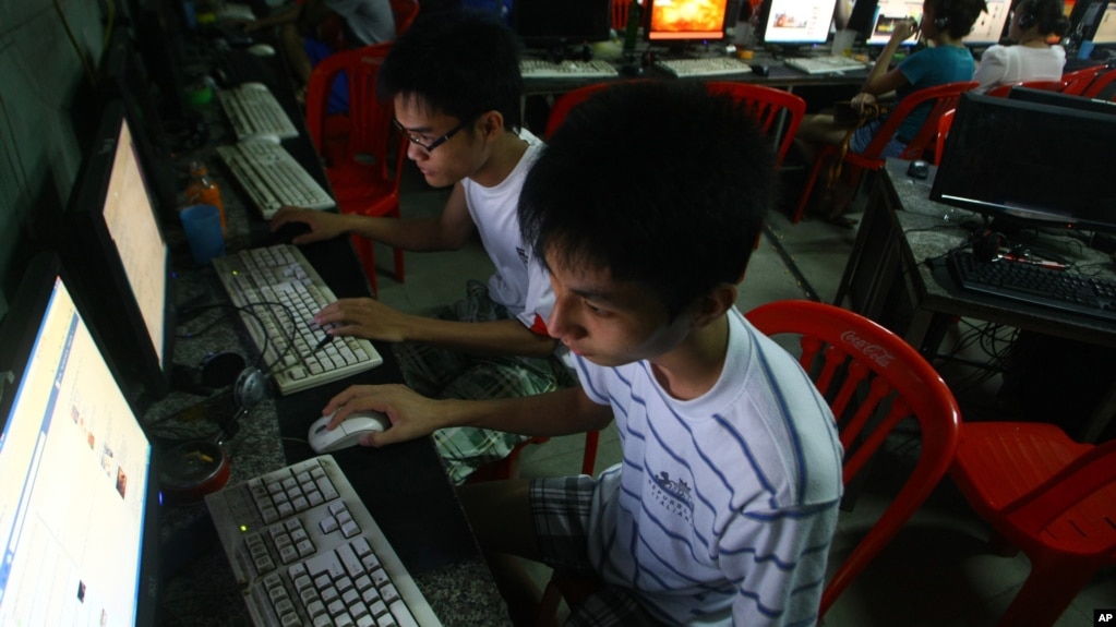 In this Sept. 27, 2012 photo, two Vietnamese students use Facebook at an internet cafe near their dormitory while they could not log in Facebook from their mobile phones because of firewall in Hanoi, Vietnam.