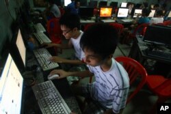 FILE - Two Vietnamese students use Facebook at an internet cafe near their dormitory in Hanoi, Vietnam.