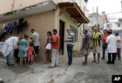 In this March 3, 2018 photo, residents stand in line to receive a free vaccine against yellow fever on the outskirts of Sao Paulo, Brazil.