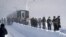 Passengers walk after getting off a train on East Japan Railway Co.'s Shinetsu Line, where they spent the night after it was stranded between stations by heavy snowfall, in Sanjo, Niigata Prefecture, Japan, Jan. 12, 2018.