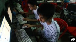 FILE - two Vietnamese students use Facebook at an internet cafe near their dormitory while they could not log in Facebook from their mobile phones because of firewall in Hanoi, Vietnam.