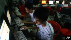 FILE - two Vietnamese students use Facebook at an internet cafe near their dormitory while they could not log in Facebook from their mobile phones because of firewall in Hanoi, Vietnam.