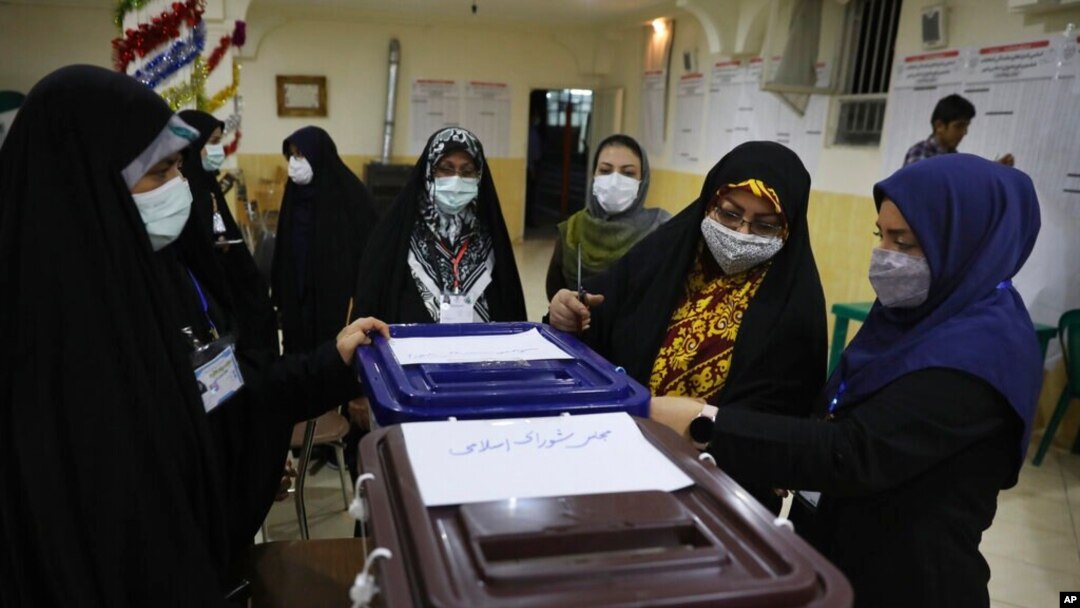 Election officials open a ballot box for the presidential elections at a polling station in Tehran, Iran, early on June 19, 2021. Iranians voted Friday in a presidential election dominated by Supreme Leader Ayatollah Ali Khamenei's hard-line protege.