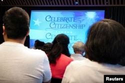 Orang-orang menghadiri upacara naturalisasi Layanan Kewarganegaraan dan Imigrasi AS (USCIS) di Perpustakaan Umum New York, di New York City, AS, 2 Juli 2024. (REUTERS/Brendan McDermid)