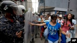 Manifestantes empujan los escudos de la policía venezolana mientras protestan contra el gobierno de Nicolás Maduro en Caracas, el 18 de Julio de 2018. La ONG Foro Penal reporta más de 15.000 presos por razones políticas en Venezuela desde 2014.