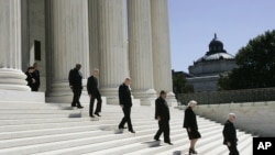 FILE - Justices walk down the steps of the Supreme Court building in Washington, Sept. 7, 2005.