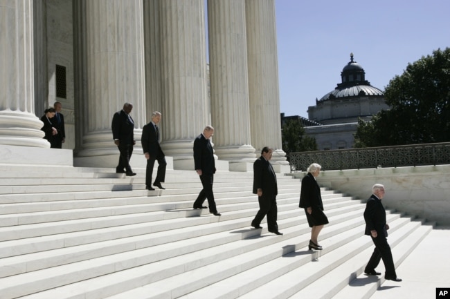 Associate justices walk down the steps of the Supreme Court as they wait for the casket carrying Chief Justice William H. Rehnquist to arrive, Sept. 7, 2005 in Washington.