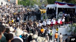 Nan moman ofisye polis yo te rive ak sèkèy la ki te gen kadav ansyen Prezidan René Préval la anba Kyòs Occide Jeanty sou plas Chamd Mas, nan Pòtoprens, Ayiti, 11 mas, 2017.