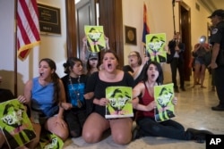 Activists protest against the Republican health care bill outside the offices of Sen. Jeff Flake, R-Ariz., and Sen. Ted Cruz, R-Texas, July 10, 2017, on Capitol Hill in Washington.