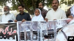 Relatives of victims of a 2007 train explosion in India hold a protest in Lahore, Pakistan, March 25, 2019. 