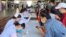 ບັນດາແພດຈາກກະຊວງສາທາລະນະສຸກ ກຳລັງກວດພວກຄົນທີ່ເດີນທາງເຂົ້າມາໃນລາວ ຜ່ານດ່ານຂ້າມຊາຍແດນຂົວມິດຕະພາບ ລາວ-ໄທ ທີ່ນະຄອນວຽງຈັນ.