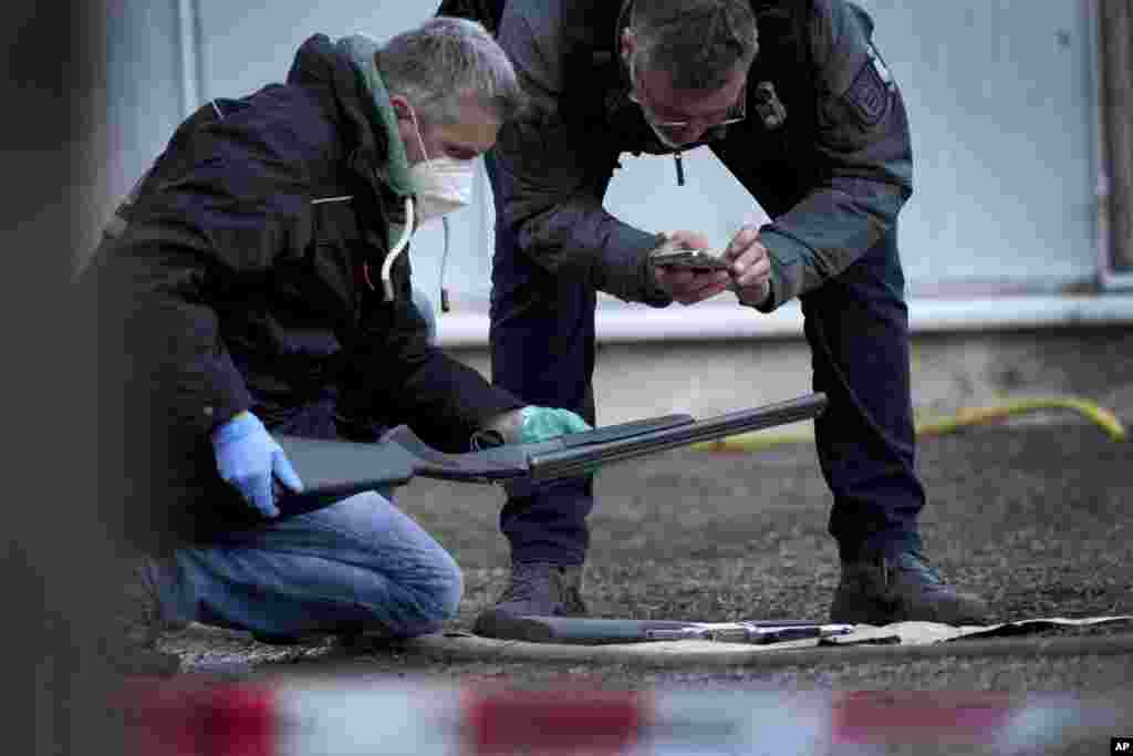 Police officers secure traces on the grounds of the Heidelberg University Botanical Garden in Heidelberg, Germany, Jan. 24, 2022. . Police say a lone gunman wounded several people at a lecture theater in the southwest city.