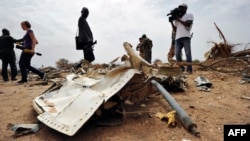 Journalists look at debris at the crash site of the Air Algerie Flight AH 5017 in Mali's Gossi region, west of Gao, July 26, 2014. 