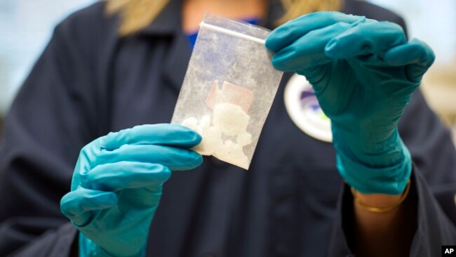 FILE - A bag of 4-fluoro isobutyryl fentanyl, seized in a drug raid, is displayed at the U.S. Drug Enforcement Administration laboratory in Sterling, Virginia, Aug. 9, 2016. The U.S. is looking to reengage with China to stop the flow of illicit synthetic drugs into the U.S.