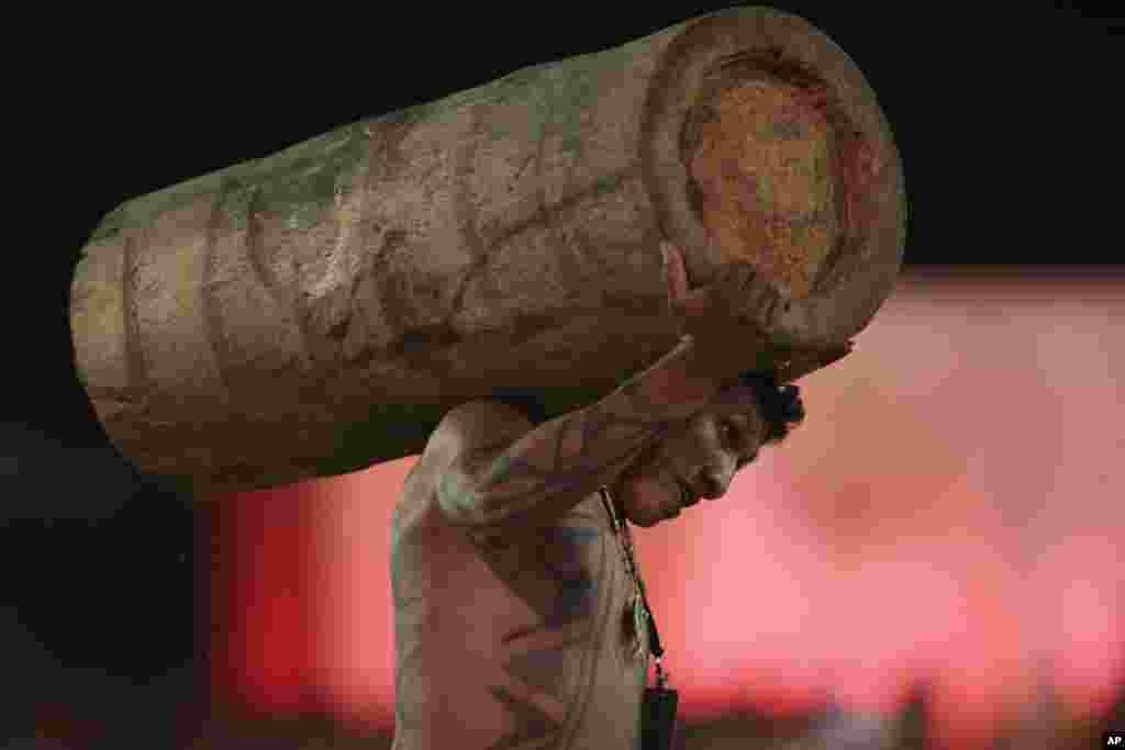 A Brazilian Xavante man carries a log during the first day of competition at the World Indigenous Games, in Palmas, Oct. 24, 2015.