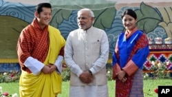 នាយករដ្ឋមន្ត្រី​ឥណ្ឌា Narendra Modi ឈរ​ក្បែរ​ព្រះមហាក្សត្រ​ប៊ូតង់ Jigme Khesar Namgyel Wangchuck (ឆ្វេង) និង​មហាក្សត្រិយានី Jetsun Pema (ស្តាំ) ក្នុង​អំឡុង​ពិធី​ទទួល​ស្វាគមន៍​នៅ​ព្រះរាជវាំង​នៅ​ក្រុង Thimphu ប្រទេស​ប៊ូតង់​កាល​ពី​ថ្ងៃ​ទី​១៥ ខែ​មិថុនា ឆ្នាំ​២០១៤។
