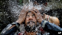 Một người đàn ông Pakistan tự làm mát dưới vòi nước để chống lại cái nóng trong tháng lễ Ramadan ở Islamabad, Pakistan, ngày 7 tháng 6 năm 2016. 