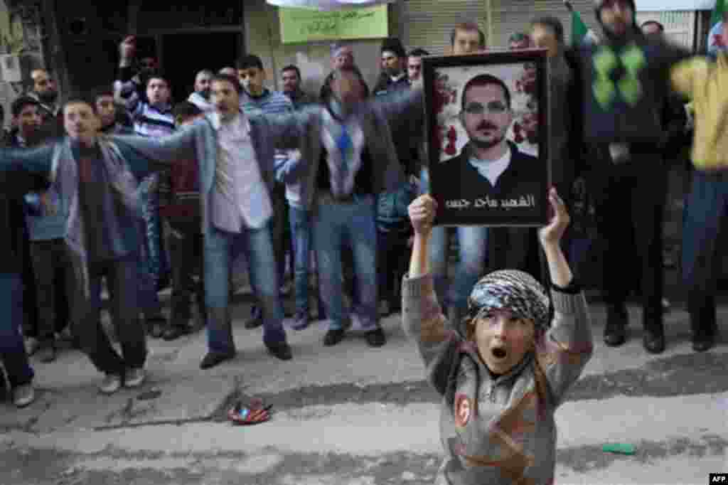 A boy holds the portrait of a man killed by the Syrian Army during a demonstration against Syrian President Bashar Al-Assad regime in Kafar Taharim, north Syria, Friday, Feb. 24., 2012. (AP Photo/Rodrigo Abd)