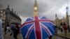 A pedestrian shelters from the rain beneath a Union Jack-themed umbrella near the Big Ben clock face and the Elizabeth Tower at the Houses of Parliament in central London, following the pro-Brexit result of the UK's EU referendum vote, June 25, 2016.