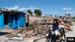 Two Cambodia's Cham Muslim women ride a motorbike with their belongings after Phnom Penh authorities asked them to leave their riverside dwellings in Chroy Changva commune, Phnom Penh city, Cambodia, on Nov. 30, 2019. (Tum Malis/VOA Khmer)